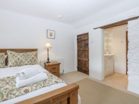 A bedroom with a wooden bed and attached washroom at Tyddyn Iolyn in Benllech