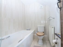 A bathroom with a bathtub and toilet at Tyddyn Iolyn in Benllech
