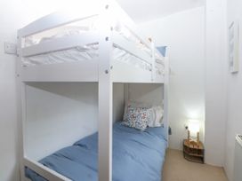 A bedroom with a bunk bed and a lamp at Tyddyn Iolyn in Benllech