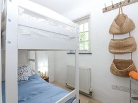 A bedroom with a bunk bed and storage baskets at Tyddyn Iolyn in Benllech
