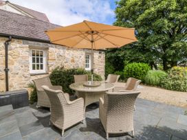 A patio area with a table and chairs at Tyddyn Iolyn in Benllech