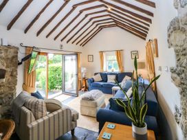 A living room with a sofa and a television at Tyddyn Iolyn in Benllech