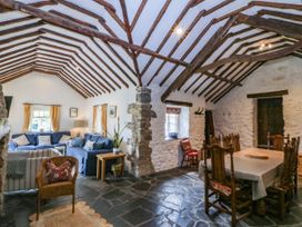 A living room with a sofa and dining table at Tyddyn Iolyn in Benllech