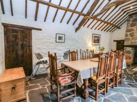 A dining room with a wooden table and chairs at Tyddyn Iolyn in Benllech