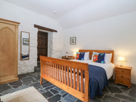 A bedroom with a bed and furniture at Tyddyn Iolyn in Benllech