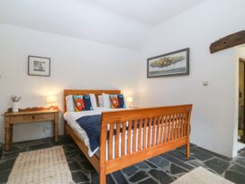 A bedroom with a bed and bedside table at Tyddyn Iolyn in Benllech