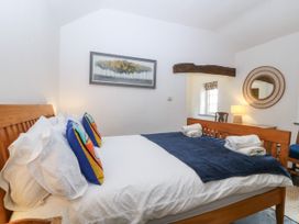 A bedroom with a bed and decorative pillows at Tyddyn Iolyn, Benllech