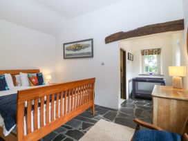 A bedroom with a wooden bed and a window at Tyddyn Iolyn in Benllech