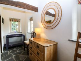 An entryway with a dresser and playpen at Tyddyn Iolyn in Benllech