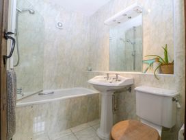 A bathroom with a bathtub, toilet, and sink at Tyddyn Iolyn in Benllech