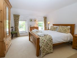 A bedroom with a bed and wardrobe at Tyddyn Iolyn in Benllech