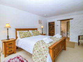 A bedroom with a bed and a bedside table at Tyddyn Iolyn in Benllech