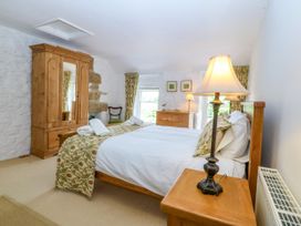 A bedroom with a bed, wardrobe, and lamp at Tyddyn Iolyn in Benllech