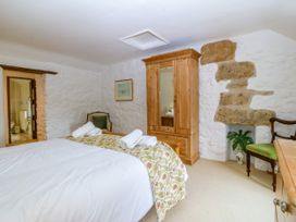 A bedroom with a double bed and wooden wardrobe at Tyddyn Iolyn in Benllech