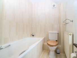A bathroom with a bathtub and toilet at Tyddyn Iolyn in Benllech