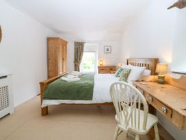 A bedroom with a bed and desk at Tyddyn Iolyn in Benllech
