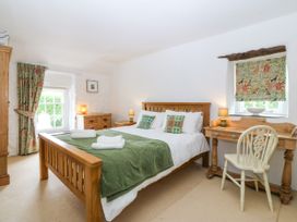 A bedroom with a bed and desk at Tyddyn Iolyn in Benllech