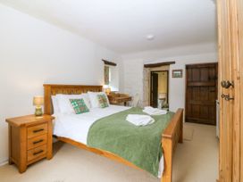 A bedroom with a bed and bedside table at Tyddyn Iolyn in Benllech