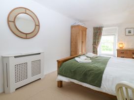 A bedroom with a bed and wardrobe at Tyddyn Iolyn in Benllech
