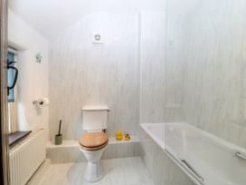 A bathroom with a toilet and bathtub at Tyddyn Iolyn in Benllech
