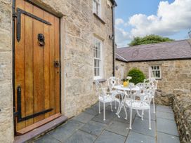 An outdoor seating area with a table and chairs at Tyddyn Iolyn in Benllech