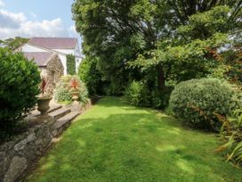 A garden with grass and plants at Tyddyn Iolyn in Benllech