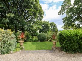 A garden with plant pots and shrubs at Tyddyn Iolyn in Benllech