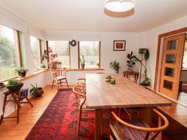 A dining room with a wooden table and chairs at Shanti Gher in Bantry