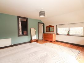 A bedroom with a bed, mirror, and chest of drawers at Shanti Gher in Bantry