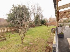 A garden with grass, trees, and a dog at Shanti Gher in Bantry