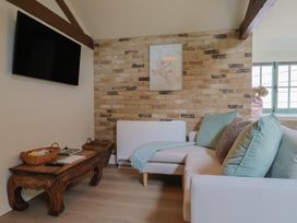 A living room with a sofa and television at Drake's Hideaway in Lyme Regis