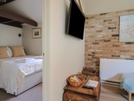 A bedroom with a bed and TV at Drake's Hideaway in Lyme Regis