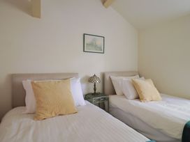 A bedroom with two beds and a lamp at Drake's Hideaway in Lyme Regis
