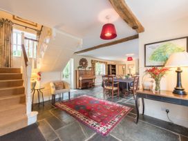 A dining room with a staircase and piano at The Coach House Lydford
