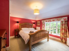 A bedroom with a bed and window at The Coach House in Lydford