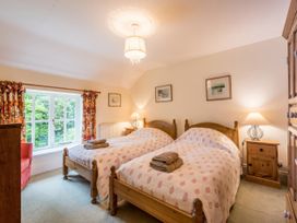 A bedroom with twin beds and a window at The Coach House in Lydford
