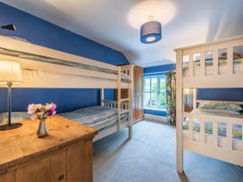 A bedroom with bunk beds and a single bed at The Coach House in Lydford