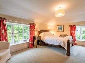 A bedroom with a bed and bedside lamp at The Coach House in Lydford