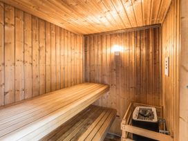 A sauna with wooden benches and a heater at The Coach House Lydford