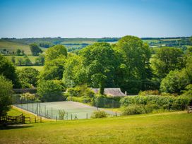 A tennis court surrounded by trees at The Coach House in Lydford