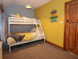 A bedroom with a bunk bed and a yellow wall with a motivational sign at Miners Rest in Blaenau Ffestiniog