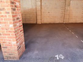 A parking space marked number 14 with brick pillar and concrete block walls