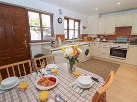 A kitchen with a dining table set for breakfast with flowers croissants and orange juice at Pebble Cottage in Whitby