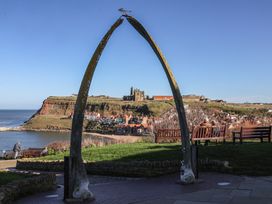 A viewpoint with whale bones and benches overlooking the coastline at Pebble Cottage in Whitby