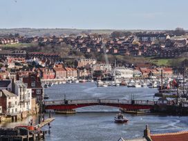 A view of a harbor with boats and houses at Pebble Cottage in Whitby