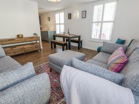 A living room with sofa and dining area at Betty's Buoy in Weymouth