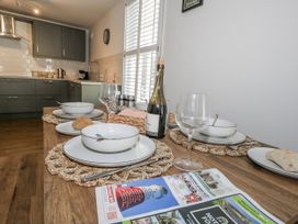 A kitchen with a dining table set up for a meal at Betty's Buoy in Weymouth