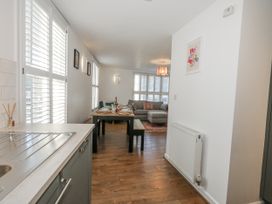 A kitchen area with a dining table and living space at Betty's Buoy in Weymouth