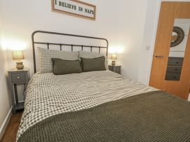 A bedroom with a bed and nightstand at Betty's Buoy in Weymouth