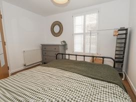 A bedroom with a bed and dresser at Betty's Buoy in Weymouth